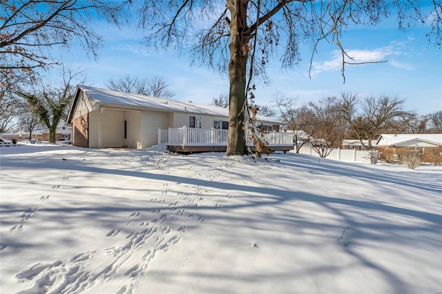 snow covered rear of property featuring a deck