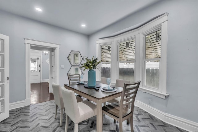 dining space featuring dark parquet flooring