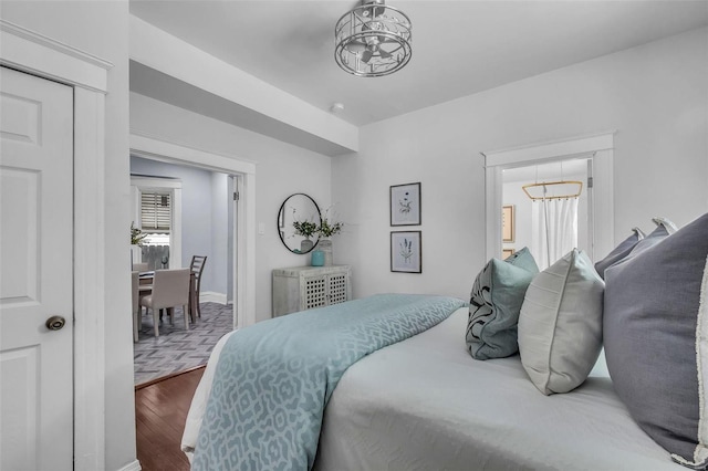 bedroom with hardwood / wood-style flooring and an inviting chandelier