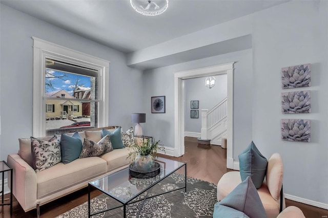 living area with wood finished floors, baseboards, and stairs