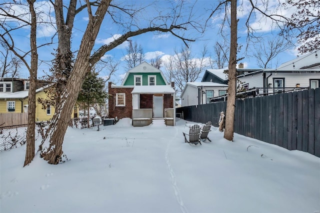 view of front of home featuring brick siding and fence