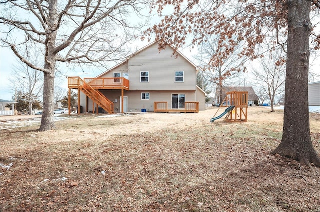 rear view of property featuring a playground and a wooden deck