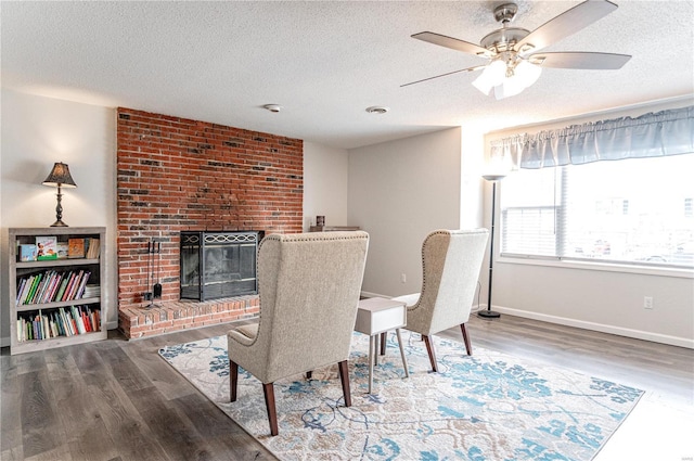 dining area with a textured ceiling, a fireplace, and wood finished floors