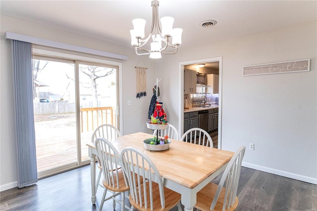 dining space with a notable chandelier, baseboards, visible vents, and dark wood-type flooring