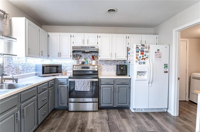 kitchen with appliances with stainless steel finishes, gray cabinets, white cabinetry, and under cabinet range hood