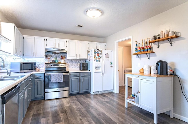 kitchen featuring stainless steel appliances, gray cabinets, light countertops, a sink, and under cabinet range hood