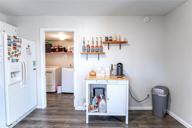 bar with white refrigerator with ice dispenser, baseboards, dark wood finished floors, and washing machine and clothes dryer