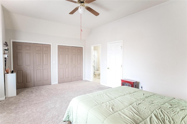 bedroom featuring carpet floors, ceiling fan, vaulted ceiling, and two closets