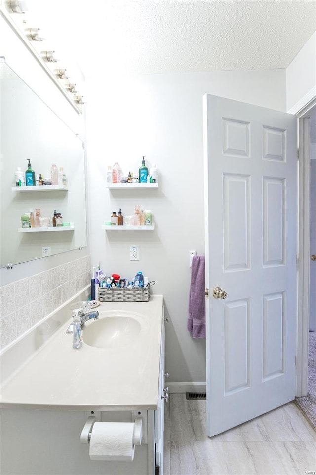 bathroom featuring visible vents, a textured ceiling, and vanity