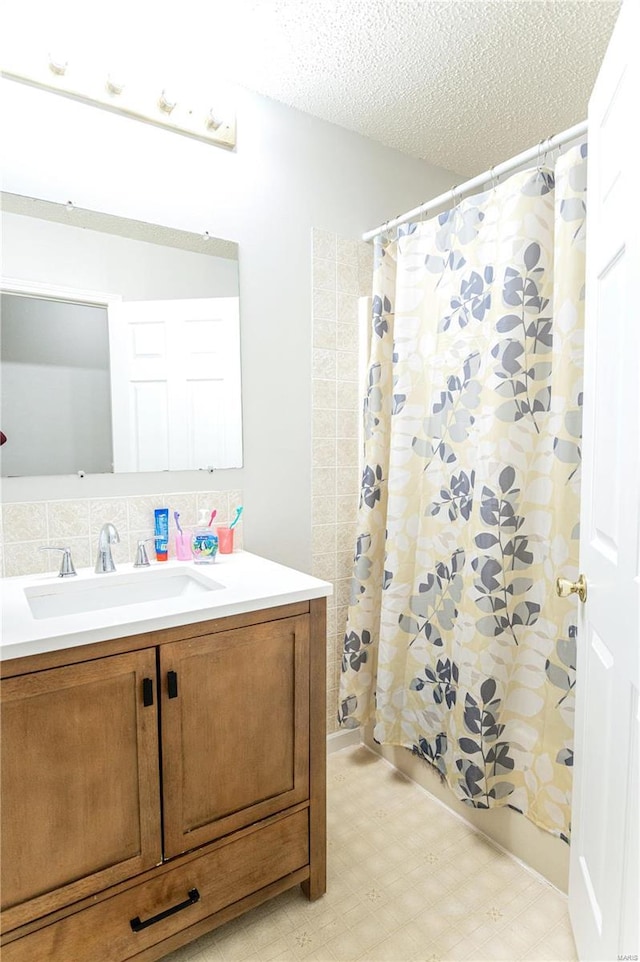 bathroom with a shower with curtain, a textured ceiling, vanity, and tile patterned floors