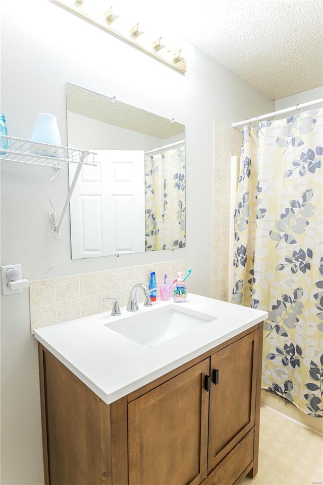 full bath with a textured ceiling, vanity, and tile patterned floors