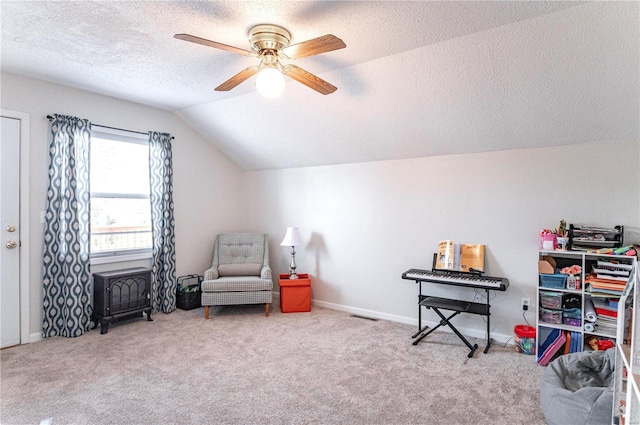 sitting room with carpet, lofted ceiling, visible vents, ceiling fan, and a textured ceiling