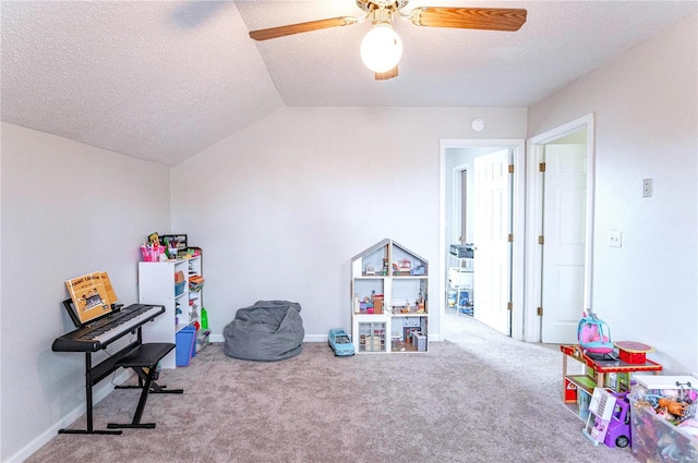 rec room featuring lofted ceiling, a ceiling fan, carpet flooring, a textured ceiling, and baseboards