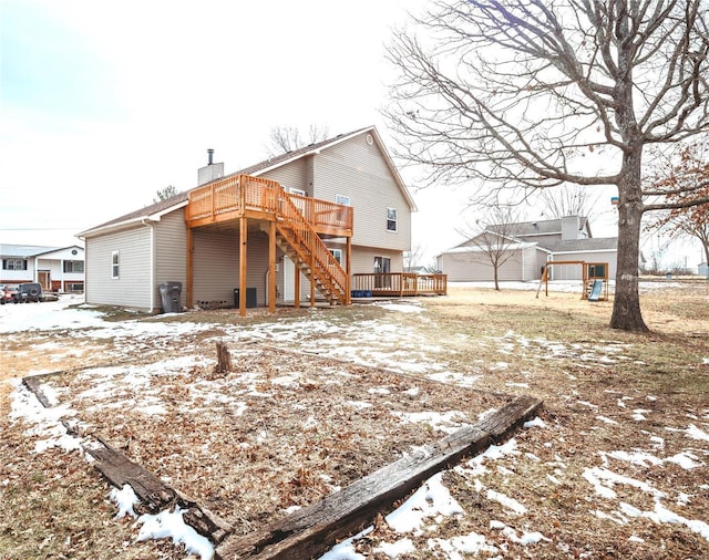 snow covered house with a chimney and a wooden deck