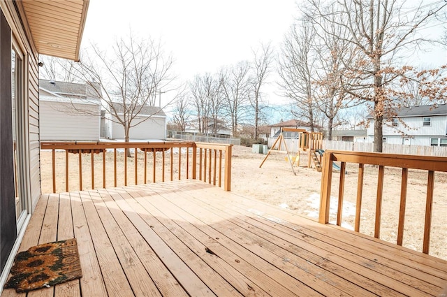 wooden deck with a fenced backyard, a residential view, and a playground