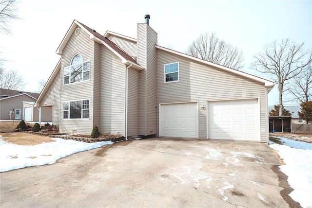 view of home's exterior with an attached garage, a chimney, and concrete driveway