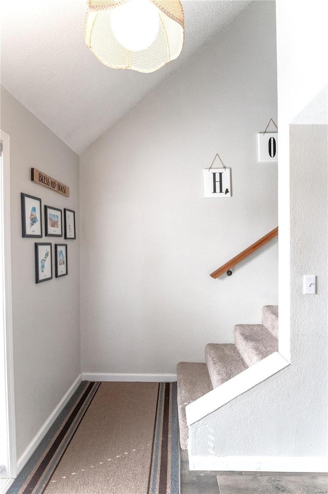 stairway featuring vaulted ceiling and baseboards