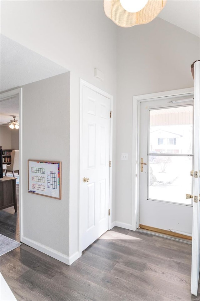 entrance foyer with ceiling fan, baseboards, vaulted ceiling, and wood finished floors