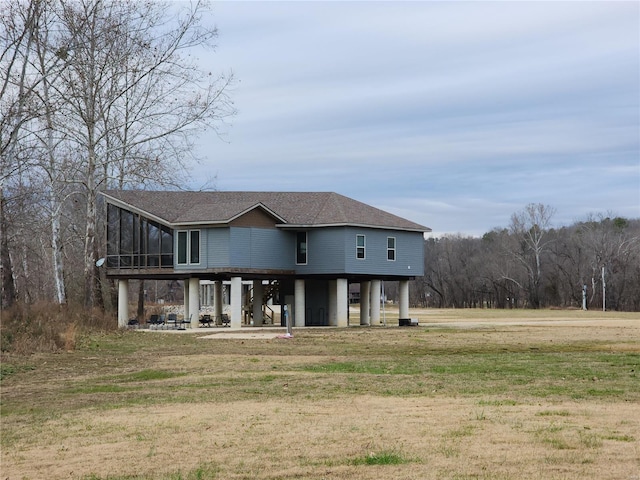 view of front of property with a patio area, a sunroom, and a front yard