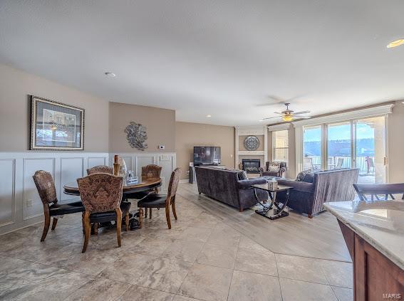 dining space featuring a large fireplace and ceiling fan