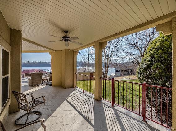 view of patio with ceiling fan and a water view