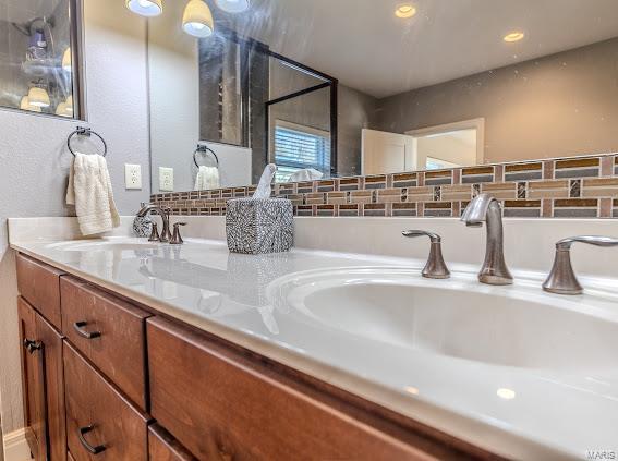 bathroom with vanity and tasteful backsplash