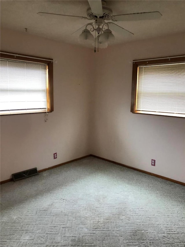 carpeted spare room featuring ceiling fan