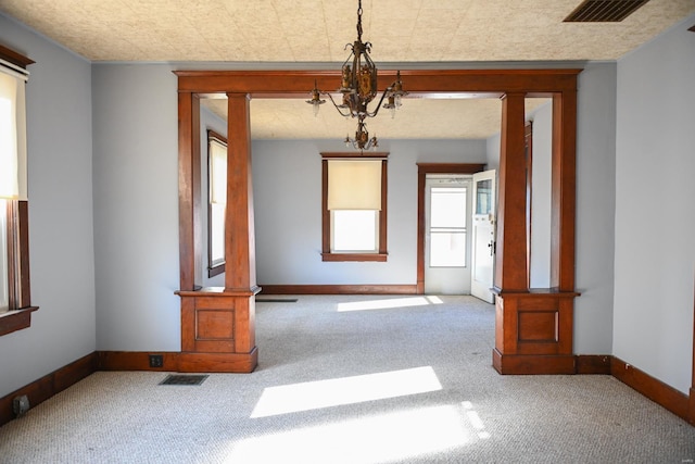 unfurnished room with carpet flooring and a chandelier