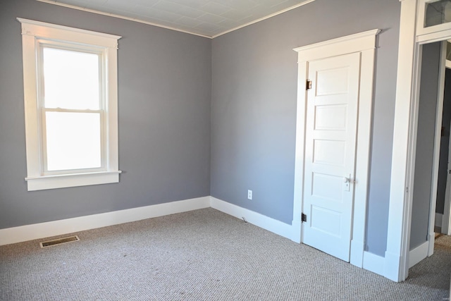 carpeted spare room featuring ornamental molding