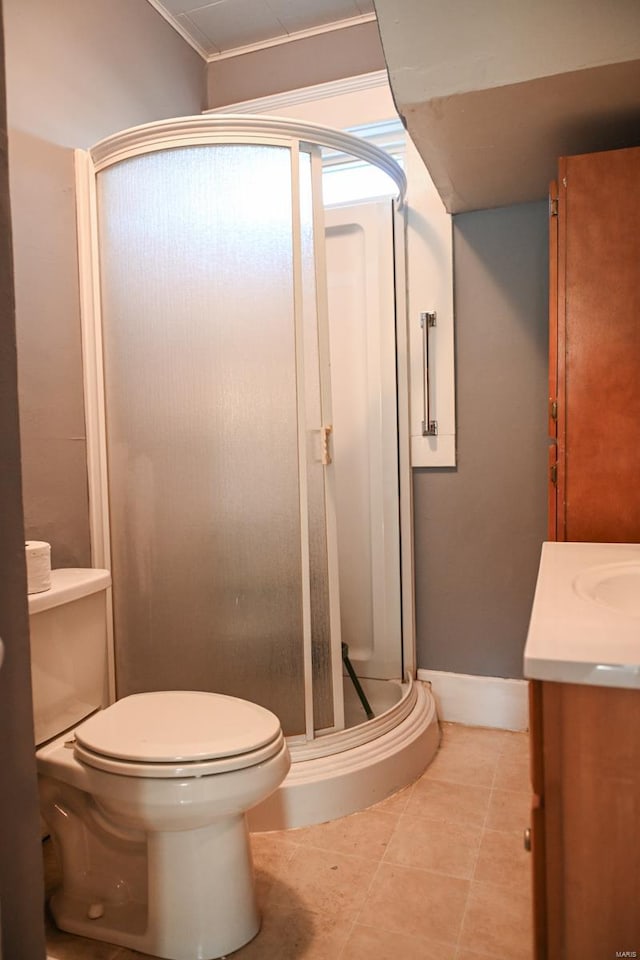 bathroom featuring vanity, tile patterned floors, crown molding, toilet, and an enclosed shower