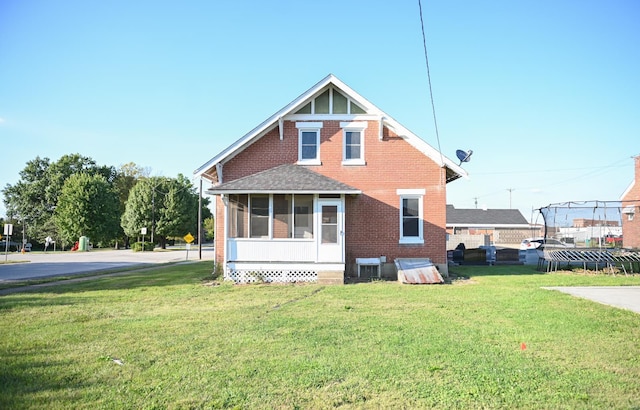 back of house with a lawn and a sunroom