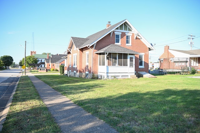 view of front of property featuring a sunroom, a trampoline, and a front lawn