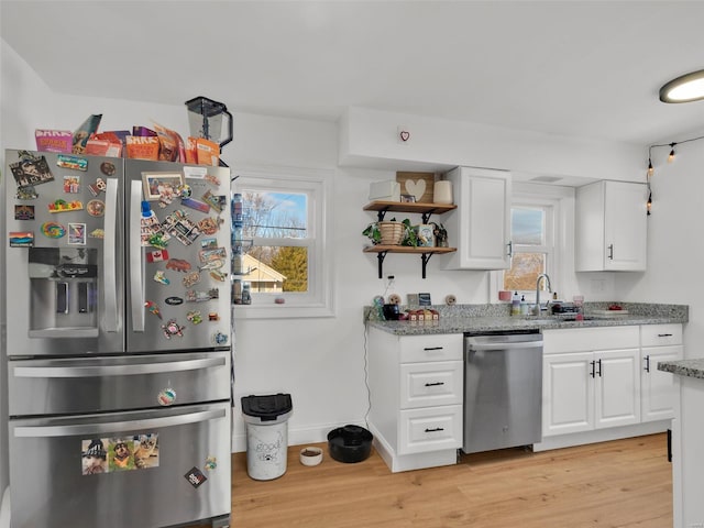 kitchen featuring white cabinets, appliances with stainless steel finishes, light hardwood / wood-style flooring, and sink