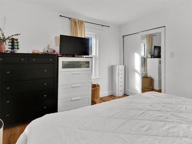 bedroom with light hardwood / wood-style flooring and a closet