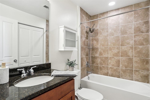 full bathroom featuring vanity, toilet, and tiled shower / bath