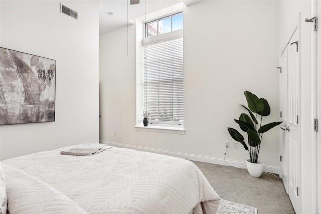 bedroom featuring light carpet and multiple windows