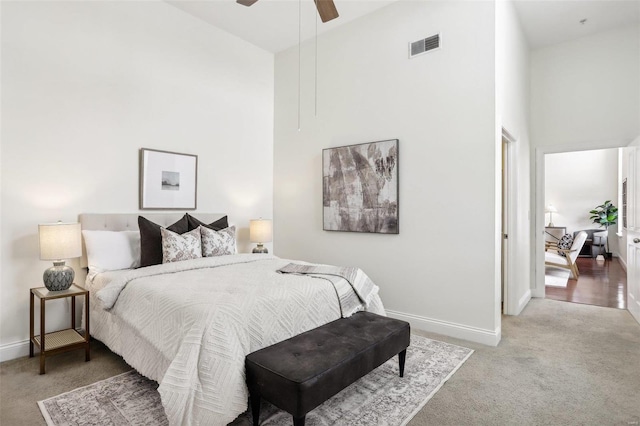 bedroom featuring ceiling fan, a towering ceiling, and carpet floors