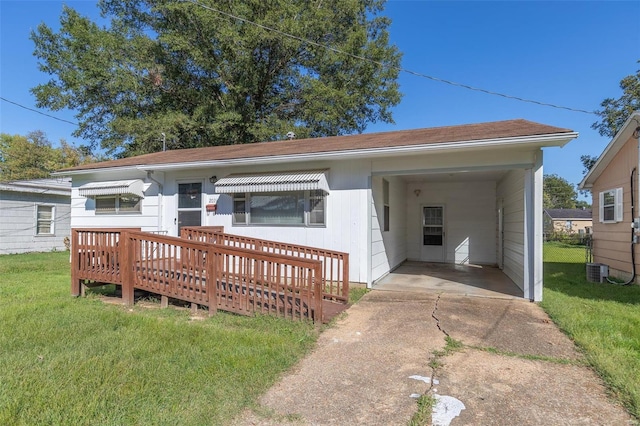 ranch-style home with a front lawn, a deck, and a carport