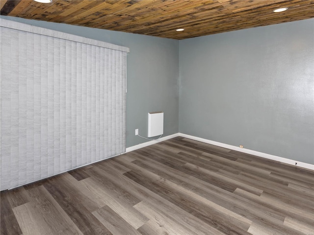 spare room featuring dark hardwood / wood-style flooring and wood ceiling