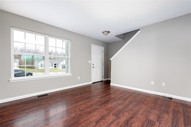 unfurnished room with dark wood-type flooring and a wealth of natural light