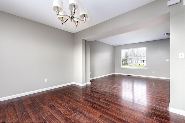 unfurnished room featuring dark hardwood / wood-style floors and an inviting chandelier