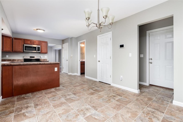 kitchen with kitchen peninsula, appliances with stainless steel finishes, decorative light fixtures, and an inviting chandelier