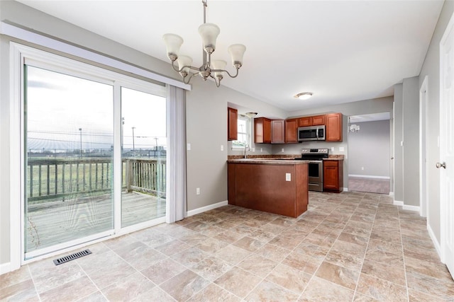 kitchen featuring kitchen peninsula, stainless steel appliances, decorative light fixtures, and a notable chandelier