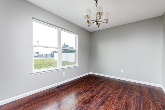 unfurnished room featuring dark hardwood / wood-style flooring and a notable chandelier