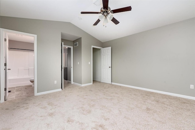 unfurnished bedroom with ensuite bathroom, ceiling fan, light carpet, and vaulted ceiling