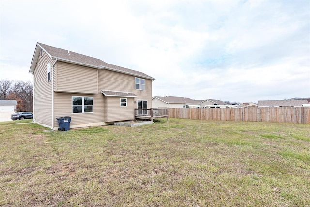 rear view of house with a wooden deck and a yard