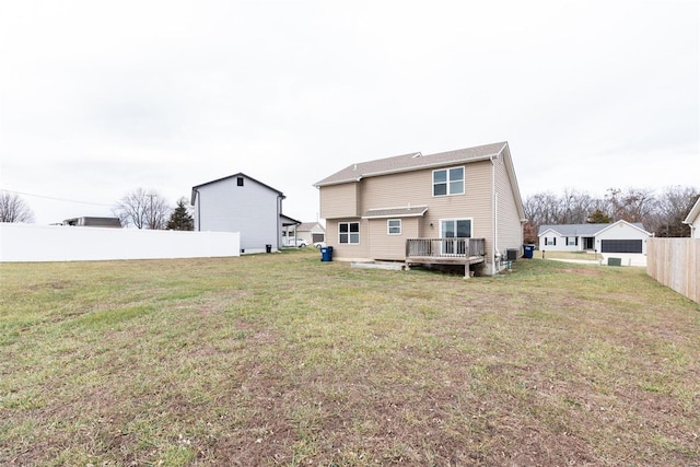 back of property featuring a deck and a lawn