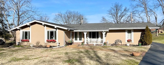 ranch-style house with covered porch and a front lawn