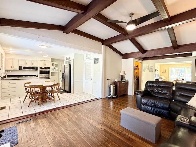 living room featuring lofted ceiling, sink, light hardwood / wood-style floors, and ceiling fan