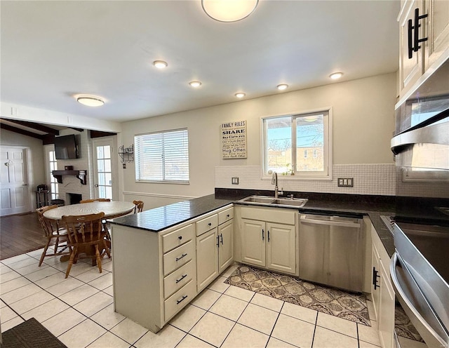 kitchen with a healthy amount of sunlight, sink, kitchen peninsula, and dishwasher